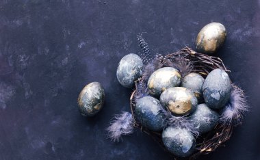Mekanın bir kopyası olan Paskalya kartı. Siyah arka planda mor, mavi ve altın yumurtalar. 2022 'nin renk trendleri çok hareketli. Doğal boya Üst Görünüm.