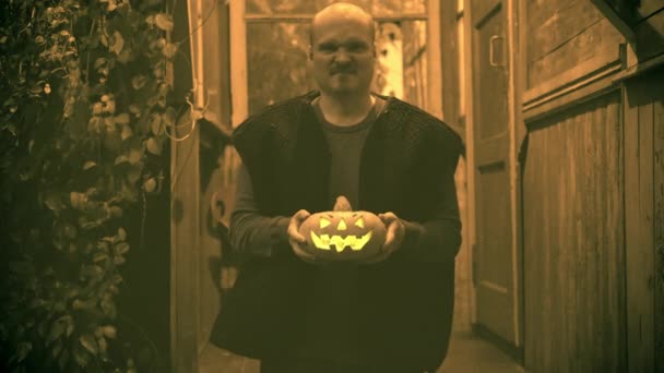 Hombre enojado con calabaza para Halloween en sus manos. Efecto vieja película dañada — Vídeos de Stock