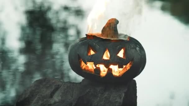 Halloween. Pompoen op de achtergrond van vijver, het gloeit, vurige vlam brandt erin — Stockvideo