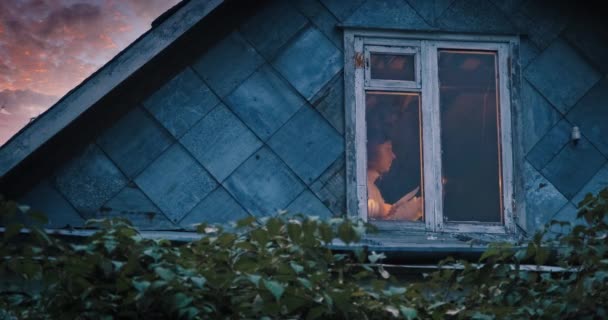 Испуганная женщина прячется с ножом и свечой в старом, мрачном доме — стоковое видео