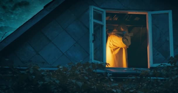 Maniak w żółtym płaszczu przeciwdeszczowym z siekierą i nożem na ostatnim piętrze starego domu — Wideo stockowe