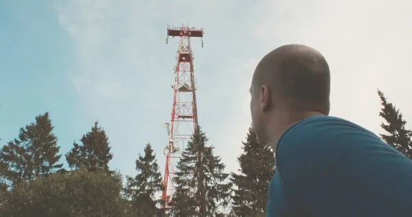 Torre de rádio celular 4G e 5G. Há um homem por perto. — Fotografia de Stock