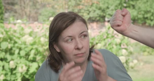 Rädd kvinna har blåtira, man hotar henne med sin näve — Stockvideo