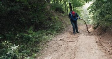 Ezik yürüyüşçü ormanda dik bir yamaçta yürür. Diz sakatlığı geçirir.