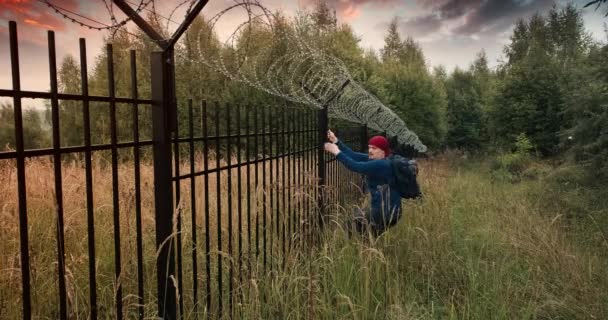 L'uomo ha scalato la recinzione con del filo spinato e ha lasciato la scena del crimine. Tramonto serale — Video Stock