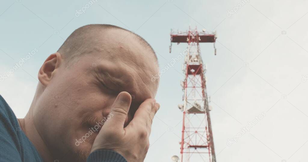 4G and 5G cellular radio tower, the man has a bad headache
