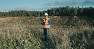 Kum havuzunun yanındaki kaskta çalışan mühendis. Adam kaynak gözlüğü takıyor.
