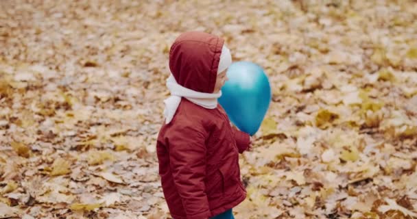 Malé dítě si hraje se svou matkou v nafukovacích balónech. Podzimní povaha — Stock video