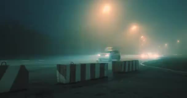 Night there is a thick fog over the highway, cars drive slowly — Stock Video