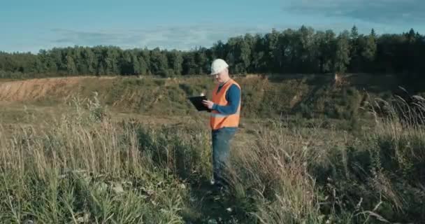 Engenheiro de trabalho no capacete ao lado da areia. Construção, empresa industrial — Vídeo de Stock