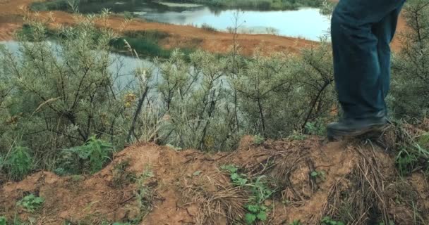 Wanderer wandern mit Rucksack im großen, sandigen Steinbruch bei Sonnenuntergang. Dort Wasser unten — Stockvideo