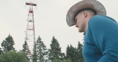 4G ve 5G baz istasyonu, yanında telefonu olan bir adam var.