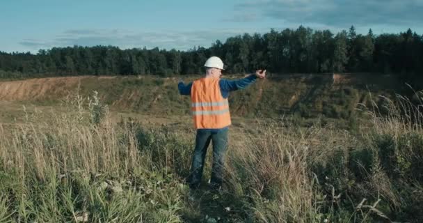 Ingeniero de trabajo en casco junto a hoyo de arena. Construcción, negocio industrial — Vídeos de Stock