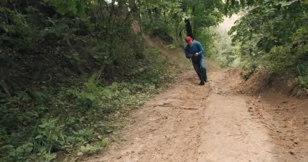 손에 전화기를 든 사람 이 반다나를 타고 한 여름 숲 속의 가파른 산비탈을 걷는다 — 비디오