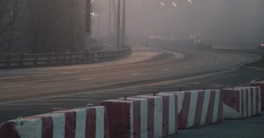 Gece, yoğun sis otoyolda. Yolun bir kısmı beton bloklarla kapatılmış.