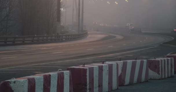 Avond, dikke mist over de snelweg. Een deel van de weg is afgesloten met betonnen blokken — Stockvideo