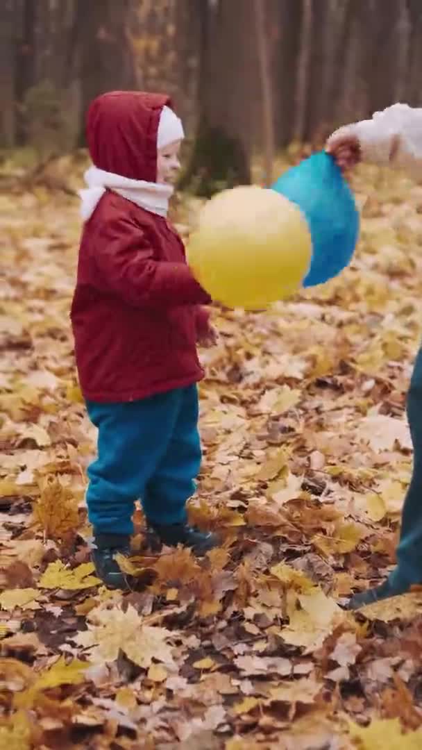 Verticale clip - Klein kind speelt met zijn moeder in opblaasbare ballonnen — Stockvideo