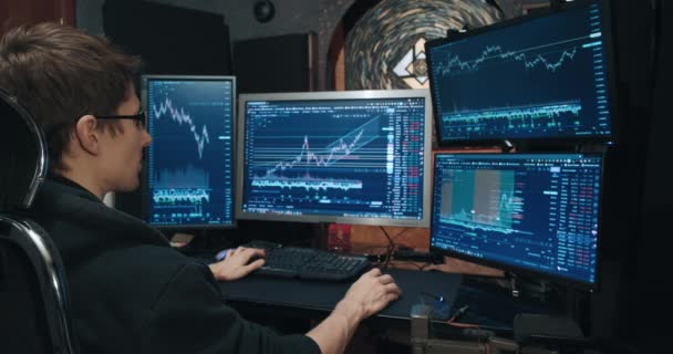 Hombre comerciante, freelancer en bolsa de valores comercios opciones en el ordenador de casa — Vídeo de stock