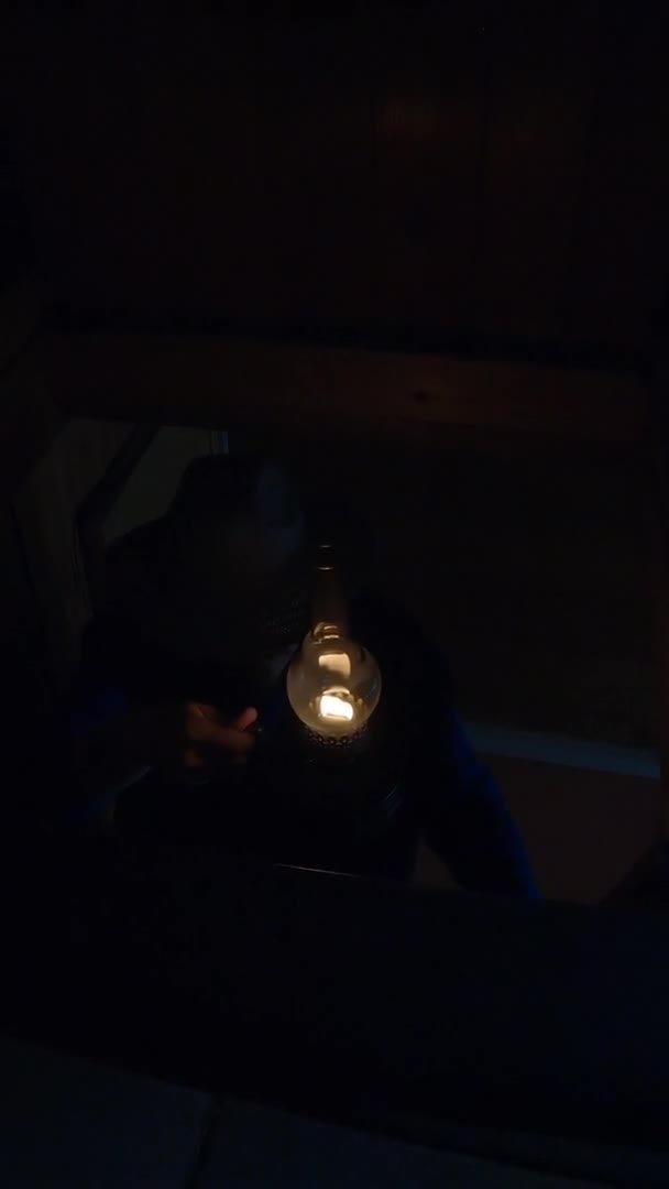 Darkness and gloom. Man with a lamp goes up the stairs - Vertical footage — Video Stock