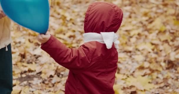 Malé dítě si hraje se svou matkou v nafukovacích balónech. Podzimní povaha — Stock video