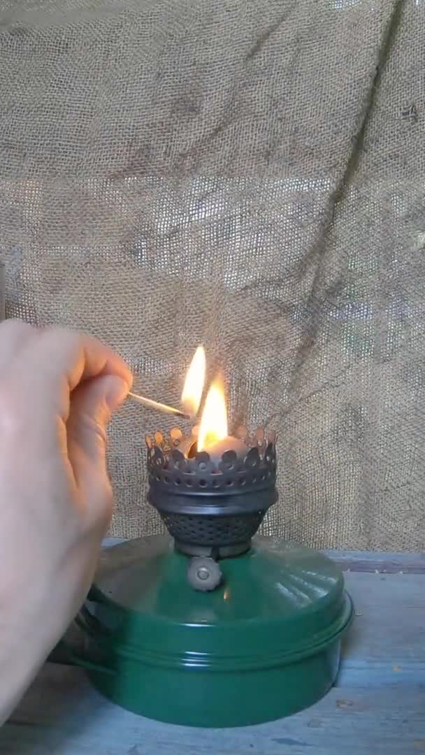 Man lights a kerosene lamp. Retro, old theme. - Vertical footage — стоковое видео