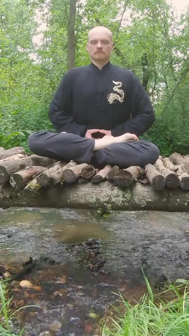 Bir adam köprüde meditasyon yapıyor - dikey görüntüler — Stok video