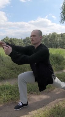 Taijiquan ve qigong 'u doğada bir ağacın gölgesinde uygula - Dikey Ekran