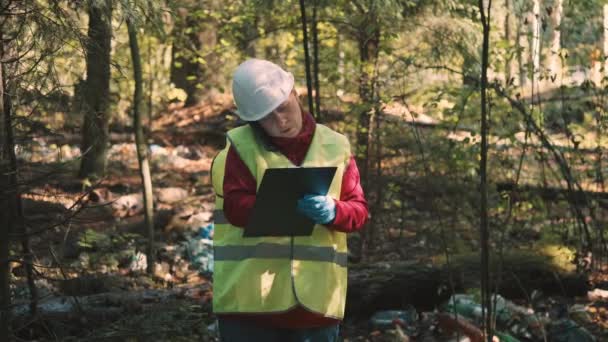 Ökológus nő munkaruha kérdések finom lerakása műanyag hulladék parkban — Stock videók