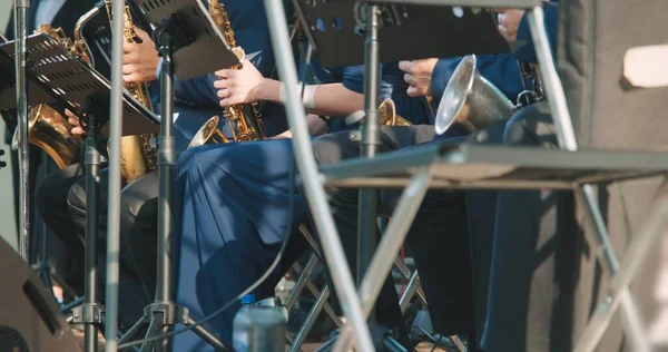 Brass band plays jazz music at concert. There is score with sheet music