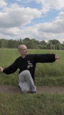 Adam rahatlamak için Çin egzersizi yapıyor. Qigong Jimnastiği - Dikey video