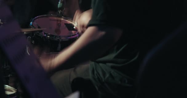 Konsert, en man som spelar trummor, ett flerfärgat ljus blinkar — Stockvideo