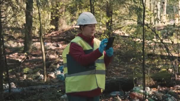 Mujer ambientalista en ropa de trabajo y casco récord de ofensa - contaminación forestal — Vídeos de Stock