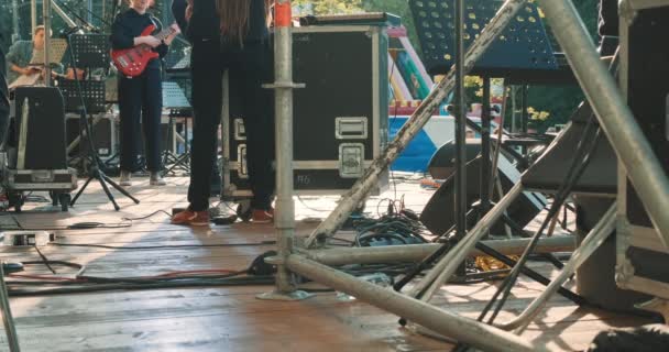 Músicos de rock en el escenario tocan guitarra eléctrica y teclados. Concierto al aire libre — Vídeos de Stock