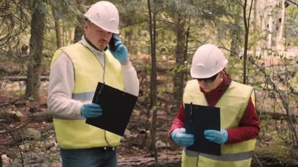 Man, woman environmentalists document offense - forest pollution and issue fine — Vídeo de Stock