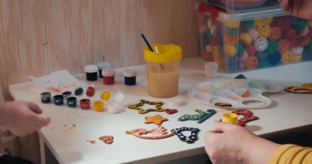 Kind met oma schildert zelfgemaakte kerstboom speelgoed gemaakt voor Kerstmis — Stockvideo