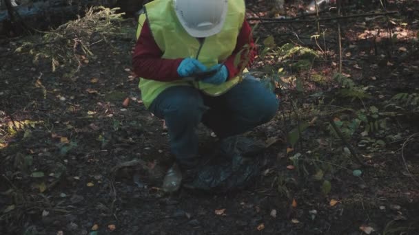 Woman environmentalist in workwear and helmet record offense - forest pollution — Stock Video