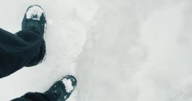 Soğuk kış aylarında ince buz üzerinde yürüyen, buzun altında akan insan ayakları.