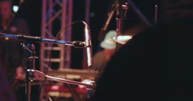 Konser, davul çalan bir adam, çok renkli bir ışık yanıp sönüyor.