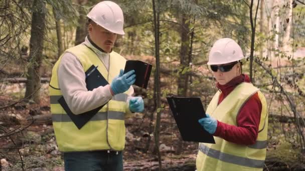 Man, woman environmentalists document offense - forest pollution and issue fine — Stock Video