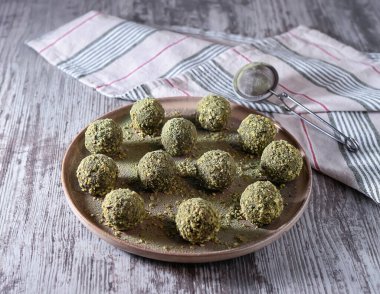 Şekersiz fıstıklı kibrit enerji topları. Vejetaryen tatlıları. Seramik tabakta yuvarlak lezzetli bir tatlı. İnsanlar için sağlıklı doğal ürünler. Kendi kendini yaptı. Seçici odak.