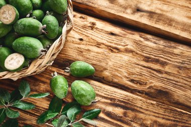 Tahta yüzeyde taze yeşil feijoa meyveleri. Guava ailesinin Acca sellowiana meyveleri. C vitamini, sağlıklı beslenme. Seçici odak.