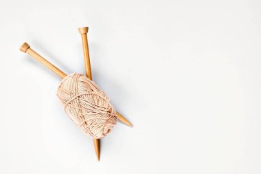 Masanın üstünde yün yumağı ve ahşap örgü iğneleri var. Hobi olarak, metin için alanı olan bir hobi. Örgü, dikiş kavramı..