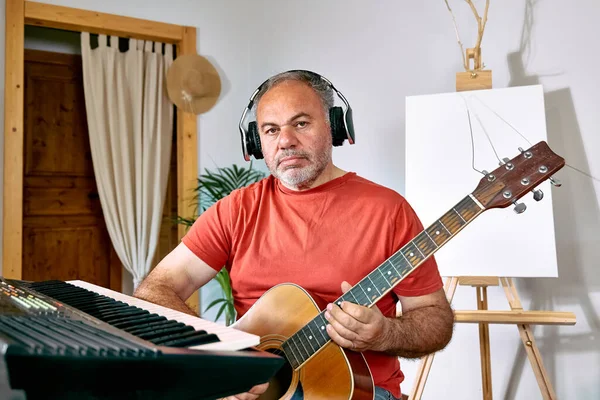 Pensive Volwassen Man Met Een Koptelefoon Spelen Akoestische Gitaar Zingen — Stockfoto
