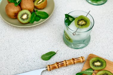 Soğuk yaz içecekleri ve içecekleri. Limonata, kivi, nane ve buzlu cam. Çeşnili alkolsüz kokteyl. Seçici odak.