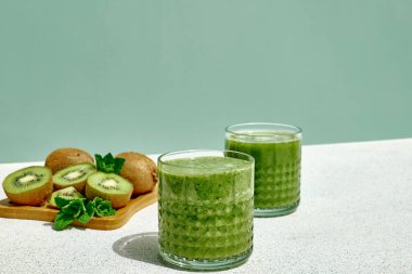 Bardaklarda kivi meyveli yeşil smoothie. Sağlıklı organik içecek. Beslenme ve alkalin diyeti. Sağlıklı beslenme vejetaryen konsepti.