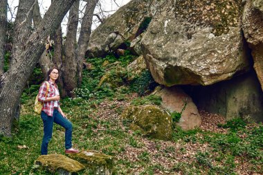 Ormanı keşfeden bir kadın, bir korulukta yürüyor, sırt çantasıyla seyahat ediyor ya da dışarıda egzersiz yapıyor. Aktif insanlar, yürüyüş, sağlıklı yaşam tarzı ve uyum kavramı. Doğayla birlik.