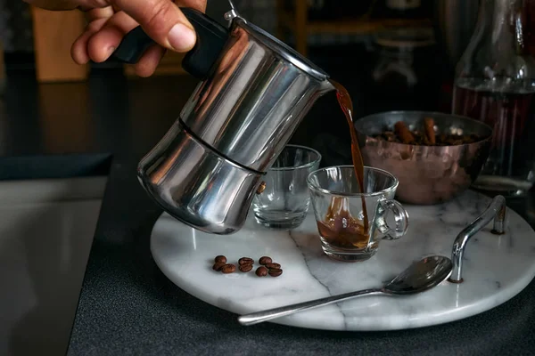 Adam mutfaktaki mocha 'da klasik İtalyan kahvesi hazırlıyor. Moka pot 'tan küçük kahve fincanına kahve dolduruyorum. Kahve freni. Sabah alışkanlığı.