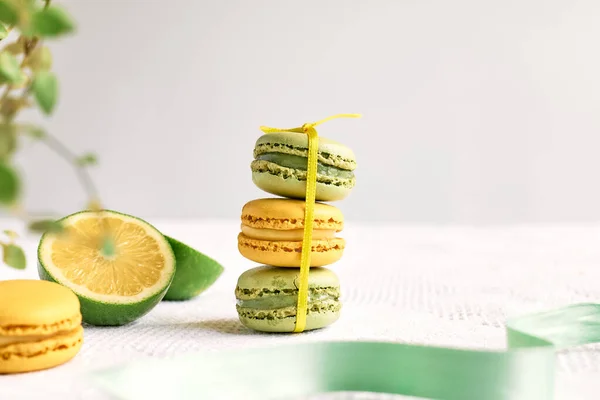 Colorful french macarons on pastel background. Tasty cake macaroon of different colors. Lemon and lime almond cookies, pastel colors.