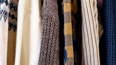 Elbise askısındaki askılara süveter ördüm. Slow Fashion. Bilinçli tüketim. Garaj satışı, tekrar kullanım giysileri, ikinci el ve çevre tüketimi kavramı.