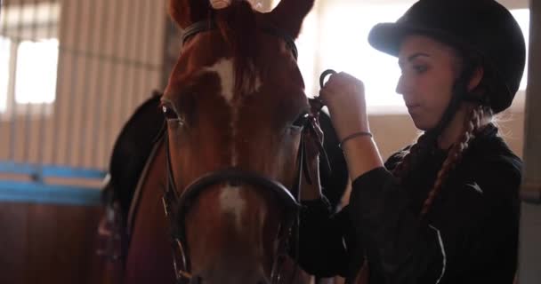 Donna che mette la staffa a cavallo a fattoria di cavallo — Video Stock